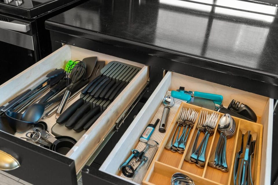 Neatly organized kitchen drawers with full utensils.