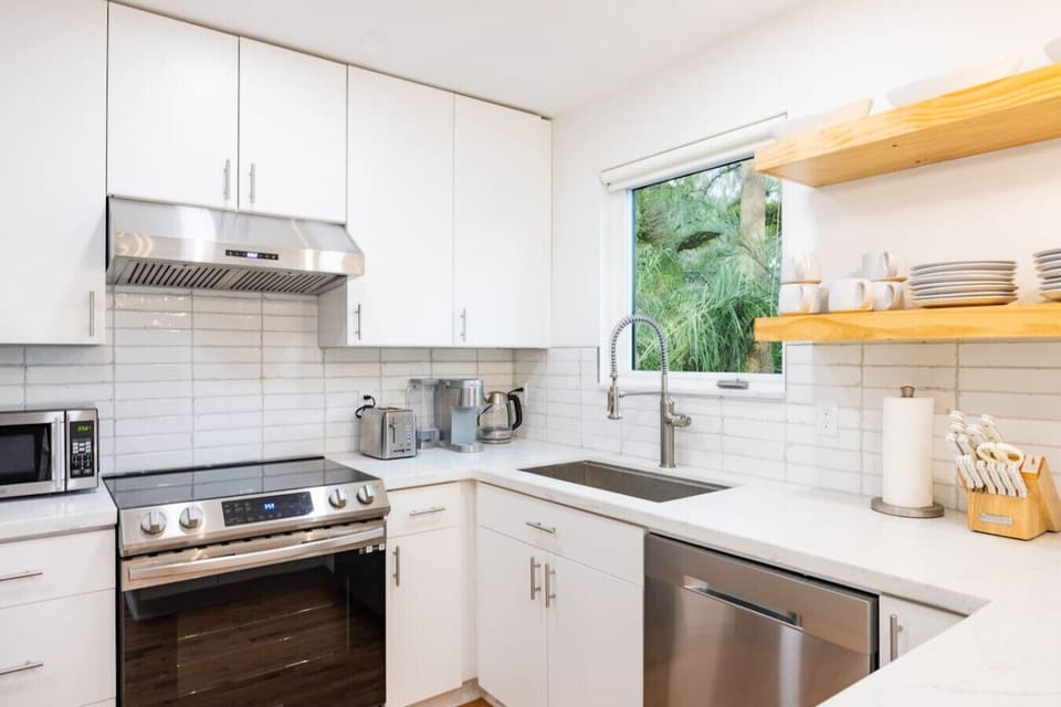 Fully equipped, modern kitchen featuring stainless steel appliances, ample counter space, and a fresh, minimalist design.