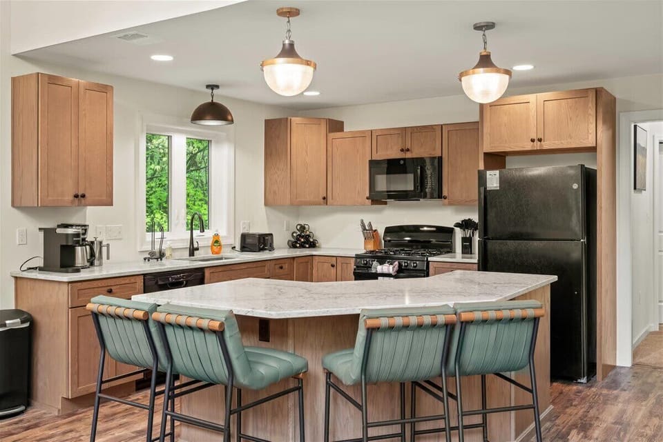 Whip up delicious meals in a fully stocked kitchen featuring a spacious island with high seating and top-of-the-line appliances—where cooking meets style and comfort.

