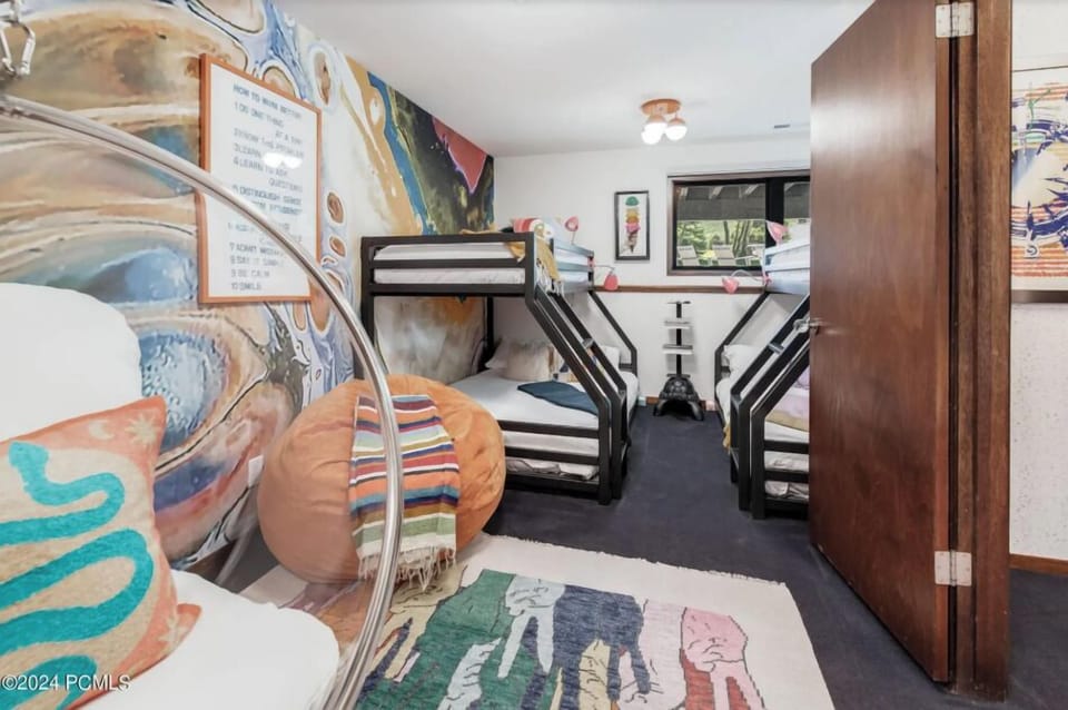 Whimsical bunk room with modern beds, colorful décor, and cozy reading nook.