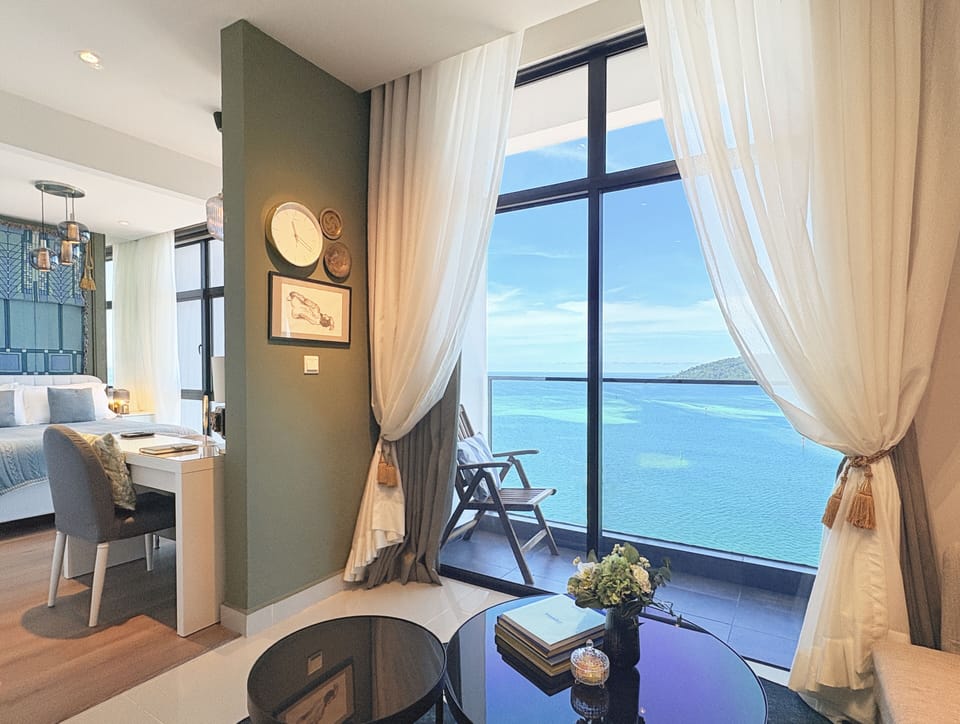Morning light& sea breeze fill the loft-a calm retreat framed by green and blue.