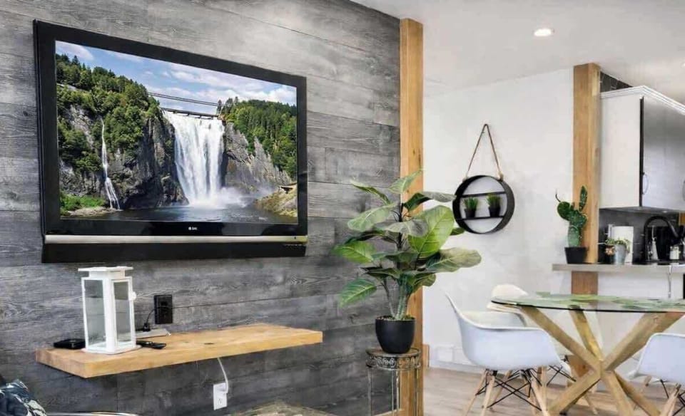 Grand salon avec Télévision - un espace élégant et confortable, doté d’un mobilier moderne, d’une grande télé et de touches vertes apaisantes.