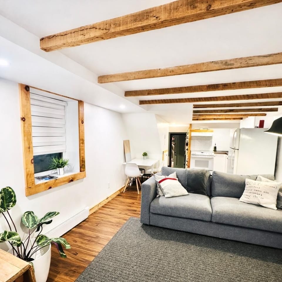 Salon : un espace lumineux et accueillant avec poutres rustiques, mobilier élégant et vue charmante — parfait pour se détendre.