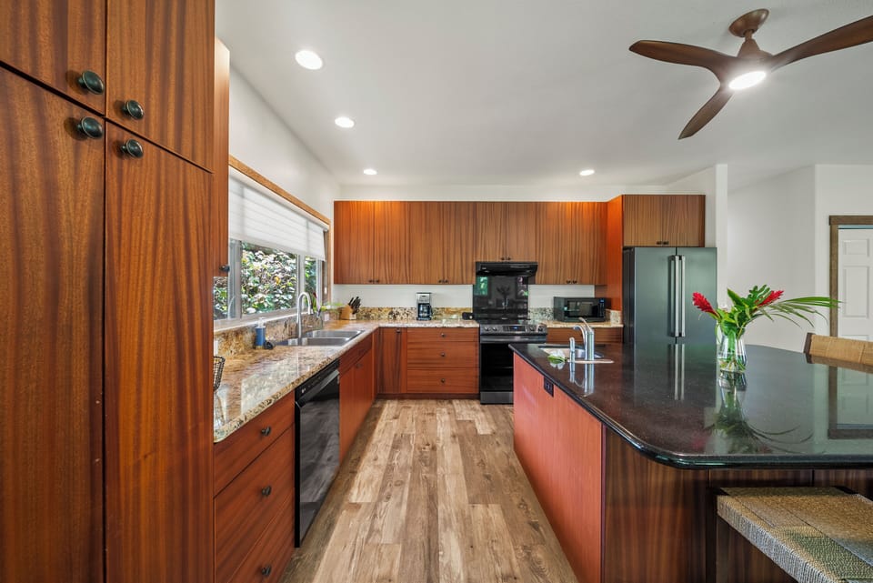 The chef's kitchen features granite countertops, wraparound cabinetry, and modern appliances for effortless cooking.