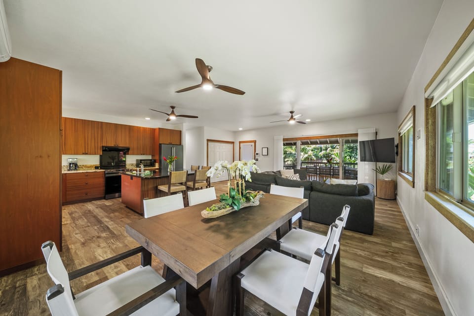 Dine together indoors with seating for eight beneath recessed lighting and island-style ceiling fans.
