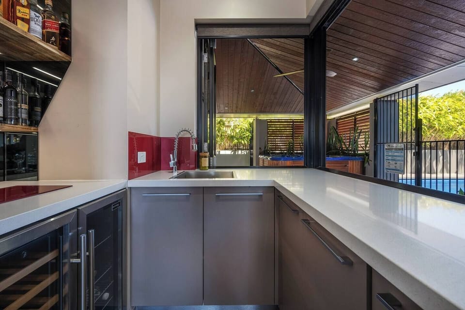 Pour a glass and unwind—this stylish spa bar features a sink, mini fridge, and servery window to the spa deck.

