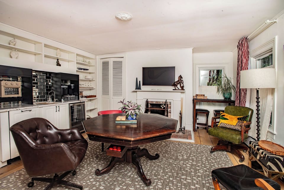 Our living / dining room, equipped with a library, smart TV, mini-fridge, toaster oven / air fryer, ice machine, Keurig coffee maker, and sink.