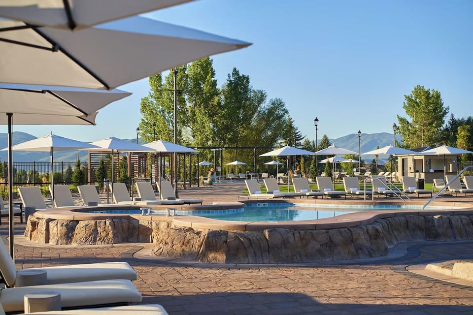 Unwind poolside with shaded seating and warm evening light.
