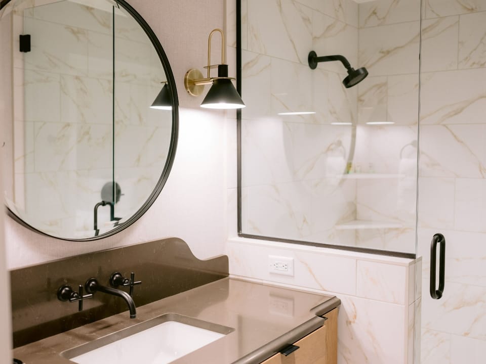 Refresh under a sleek glass shower with spa-like finishes.