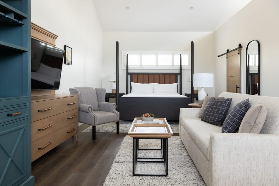 Unwind in a sunlit suite with plush bed and sofa.