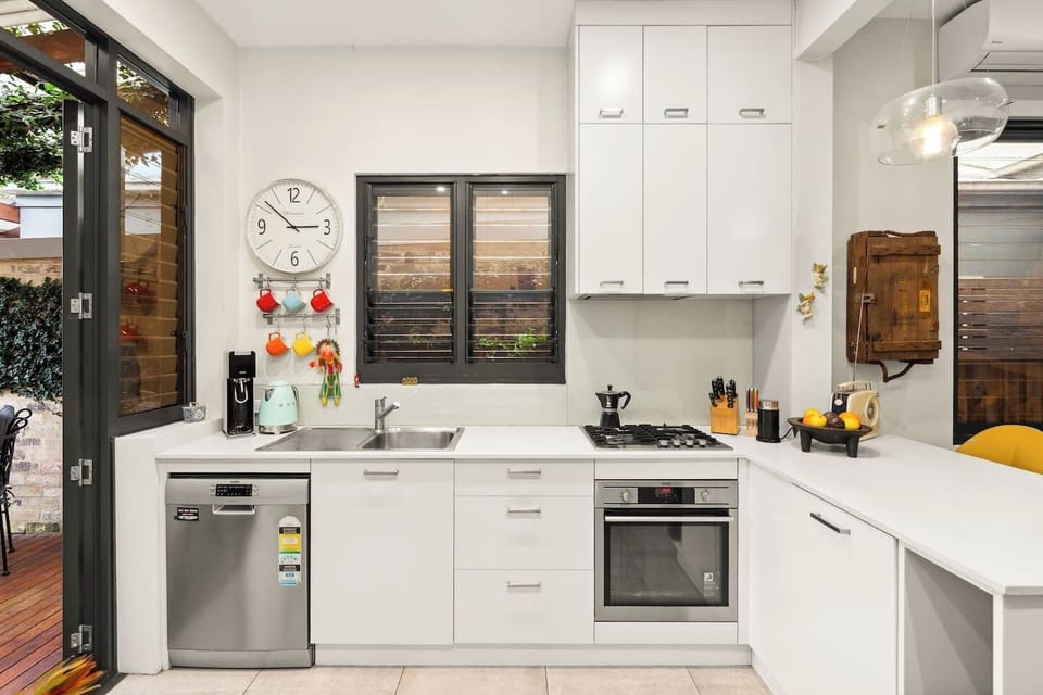 Cook up a storm in the contemporary kitchen, complete with a gas cooktop, oven, dishwasher, and thoughtful touches like open shelving and hanging mugs.
