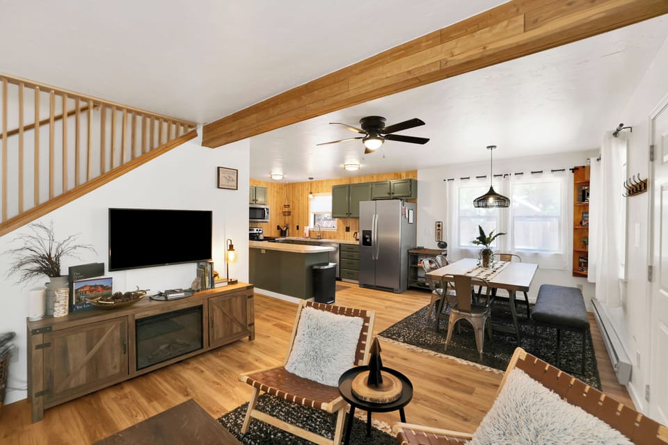 Cozy living room with plush seating, smart TV & forest-inspired decor.