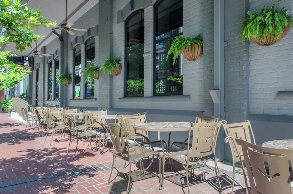 Sip coffee outdoors under leafy shade on the patio.