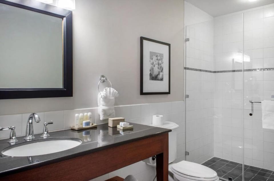 Refresh in a spotless bath with glass shower enclosure.