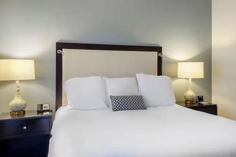 Sink into crisp linens beneath warm, glowing bedside lamps.