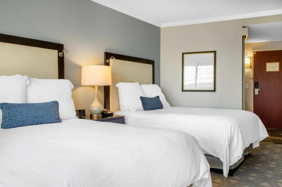 Unwind in crisp twin beds with warm bedside lighting.