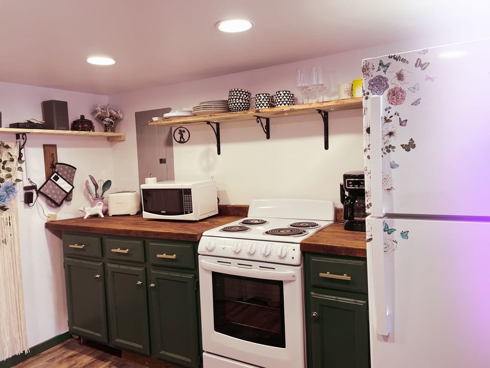 Fully stocked kitchen, coffee machine, stove, pots, pans, utensils. 