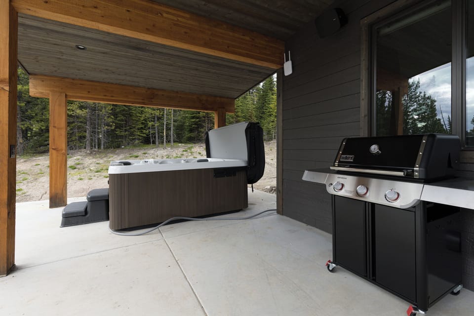 The covered patio has a grill and a private hot tub | Exterior