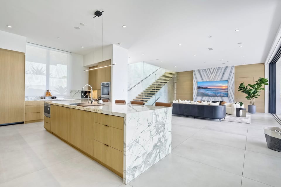 The gourmet kitchen showcases a striking waterfall marble island