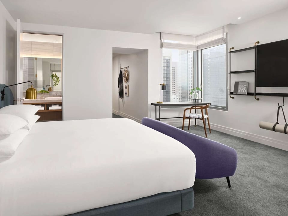 King City View - Bedroom with a plush bed, workspace, TV, and private bathroom