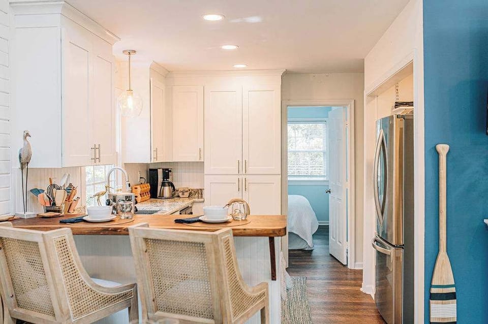Crisp white cabinetry, wood accents, and stainless appliances give this kitchen a clean coastal feel with all the comforts of home.