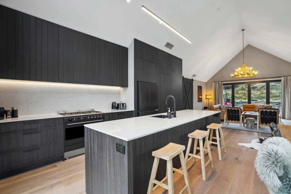 Designer kitchen with sleek cabinetry, stone benchtops, and high-end appliances, seamlessly flowing into the open-plan living space for modern family living.