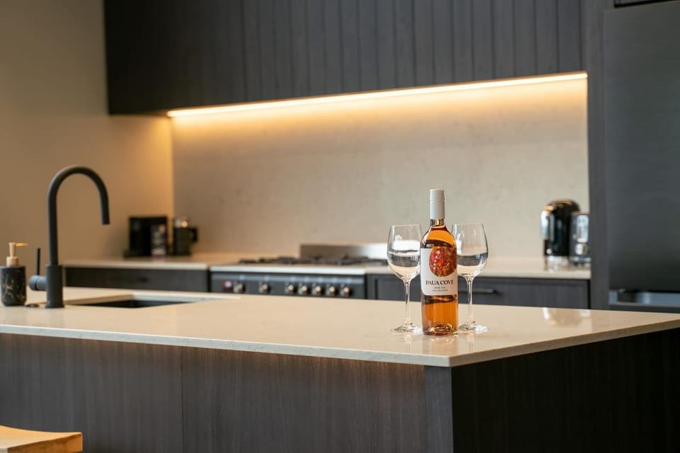 Designer kitchen with sleek cabinetry, stone benchtops, and high-end appliances, seamlessly flowing into the open-plan living space for modern family living.