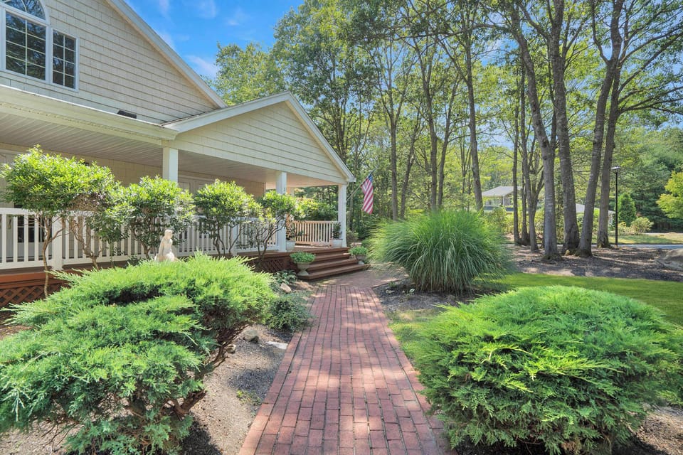 Brick walkway to covered front porch with mature plantings