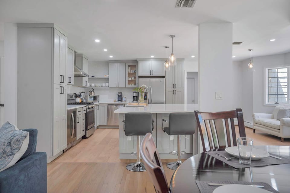 Kitchen and dining area with island bar seating and stainless appliances