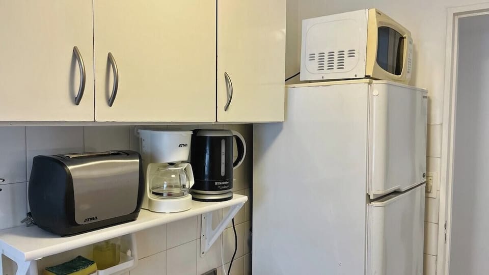 Cocina completa con heladera con freezer, microondas, cafetera, pava eléctrica, tostadora y variedad de utensilios para cocinar cómodamente.