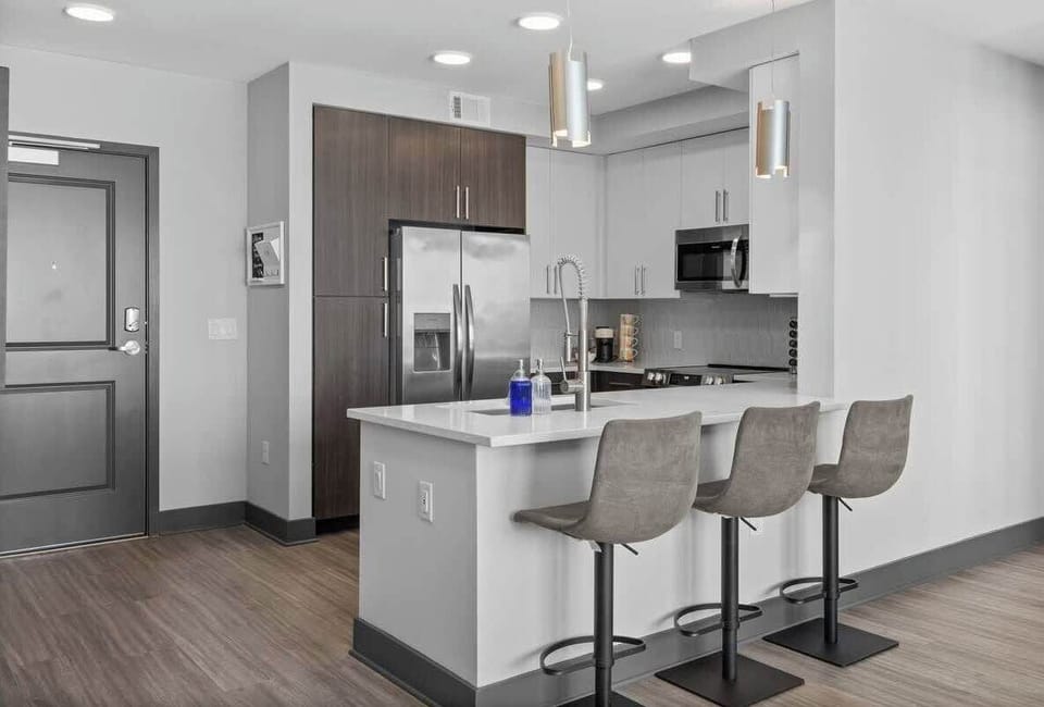 - Modern shared  kitchen island with bar seating for casual dining  
- Stainless appliances support extended stay cooking  
- Open concept layout perfect for work trips and vacations  
