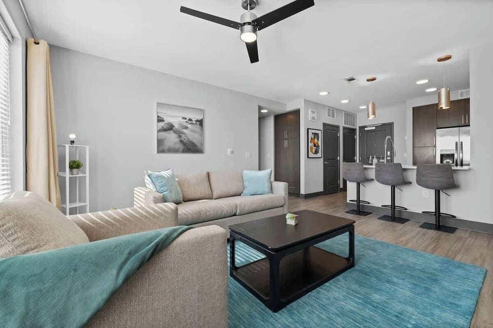 - Modern living room with soft seating and bright accents  
- Open concept enhances guest comfort during stays  
- Natural lighting makes this short term rental feel inviting  
