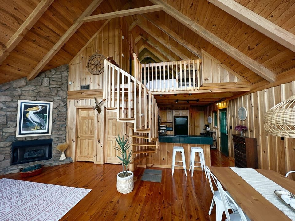 The open area of the cabin is designed to blend seamlessly with the natural beauty of the surroundings, offering an unobstructed view of the sparkling lake. Large windows frame the breathtaking scene, filling the space with light and offering the perfect 