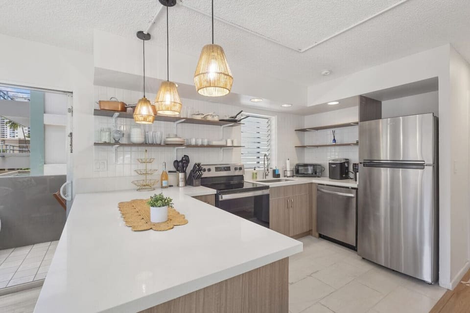 Modern kitchen featuring sleek stainless-steel appliances, open shelving, and stylish lighting—fully equipped for effortless cooking and entertaining.