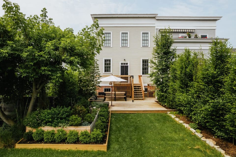Private backyard with lush greenery and deck access.