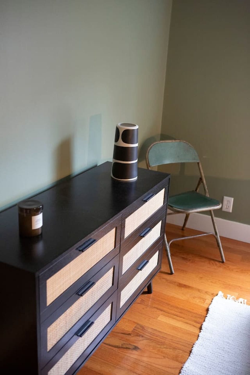 Bedroom with dresser, seating, and hardwood floors