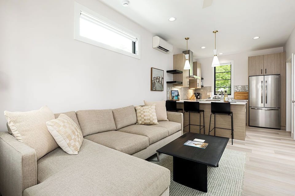 Gather and unwind in this light-filled living room, where a comfy sectional and sleek entertainment setup create the perfect hangout space