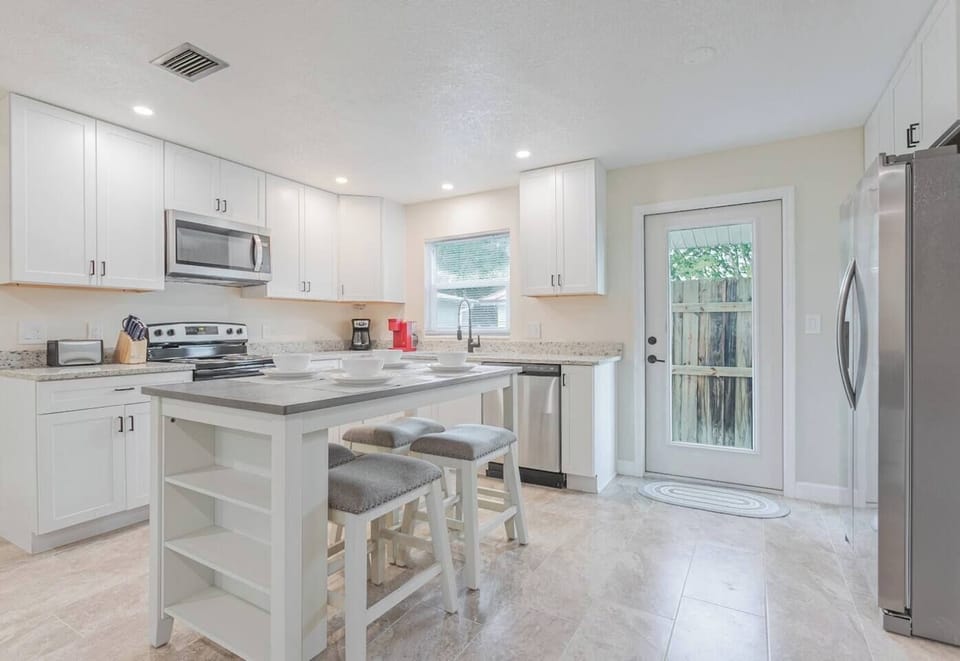 Full kitchen with fridge/freezer and door to the rear yard