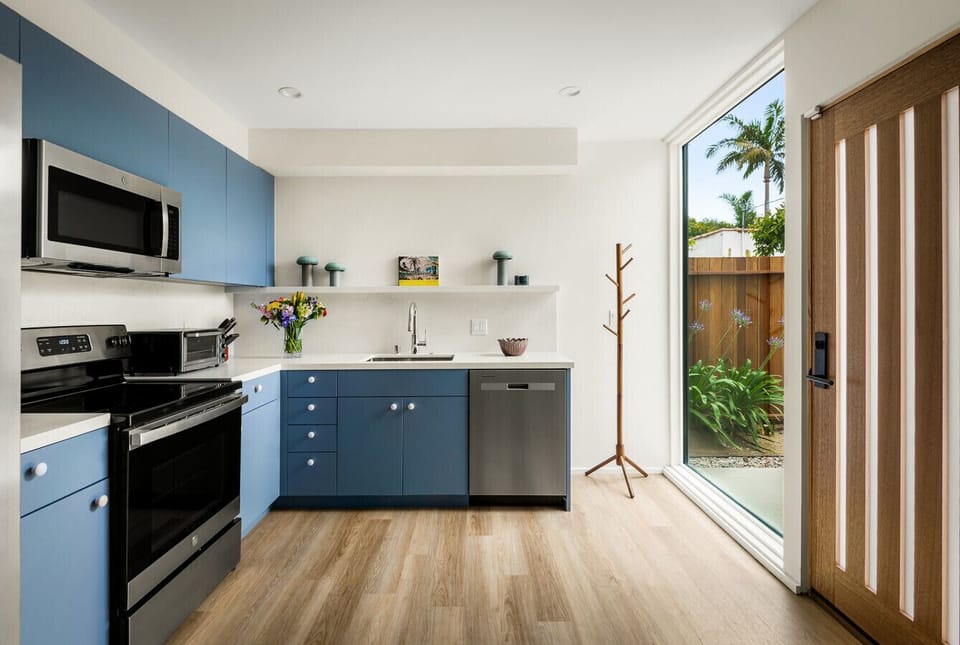 A fresh take on kitchen design with soft blue cabinets, warm wood floors, and a touch of floral elegance.
