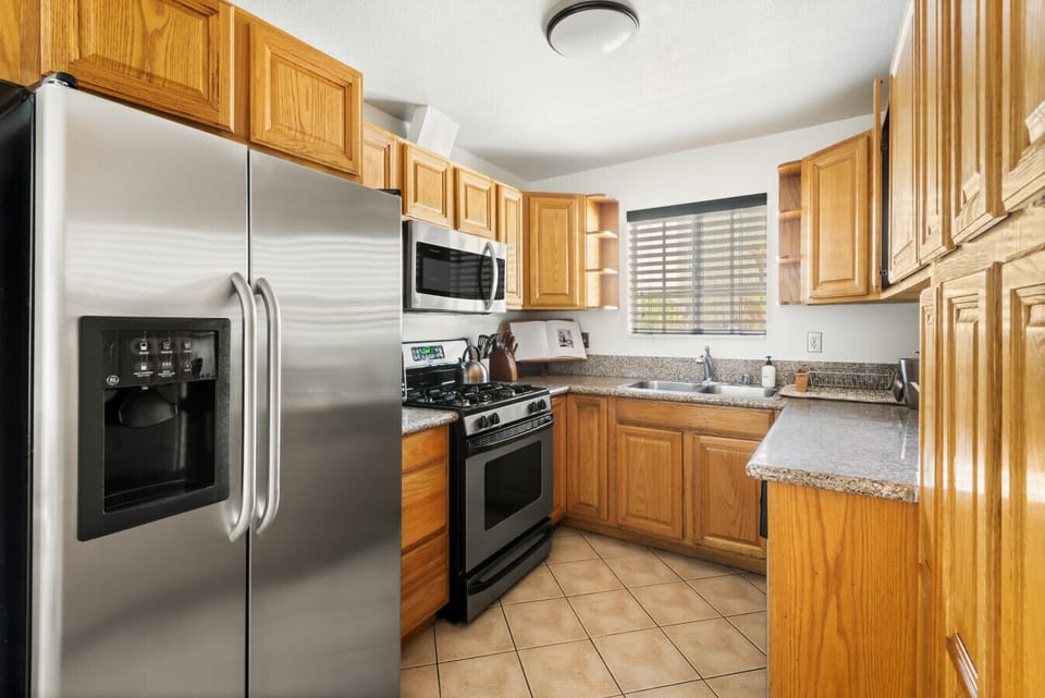 `Fully equipped stacked kitchen with a spacious fridge and warm wooden cabinetry