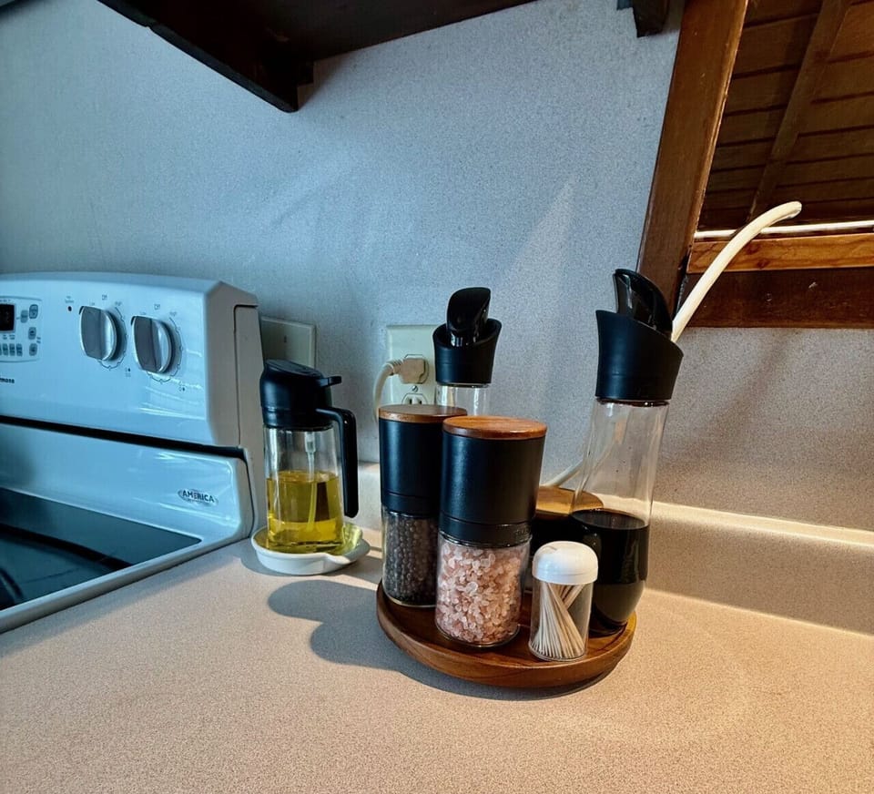 Well-stocked seasoning station with oil, vinegar, salt, pepper, and toothpicks for your cooking needs.