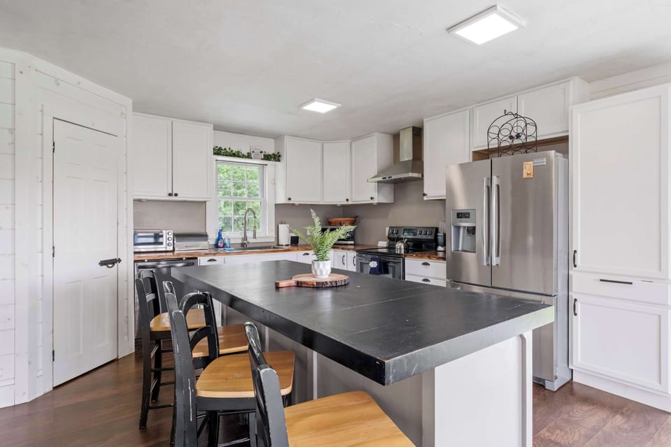 Welcome to your culinary home base—this fully equipped kitchen is as functional as it is beautiful, featuring stainless steel appliances, a spacious island, and views of lush greenery right from the sink.