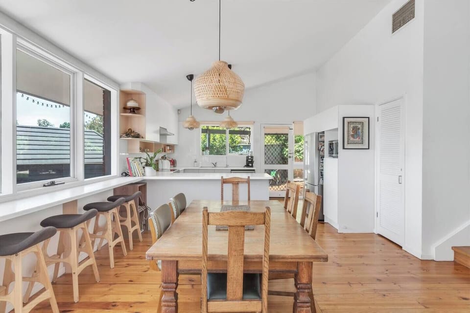A central dining table encourages shared meals at home and opens to the outdoor deck.