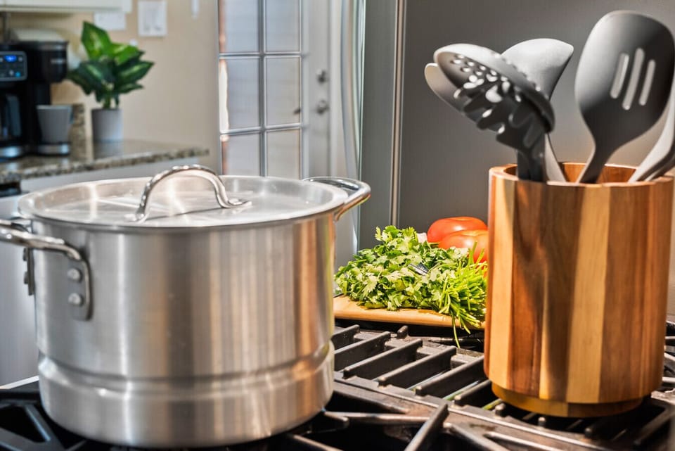 Fully stocked kitchen with quality pots, cooking spoons, and essential cutlery for all your culinary needs.