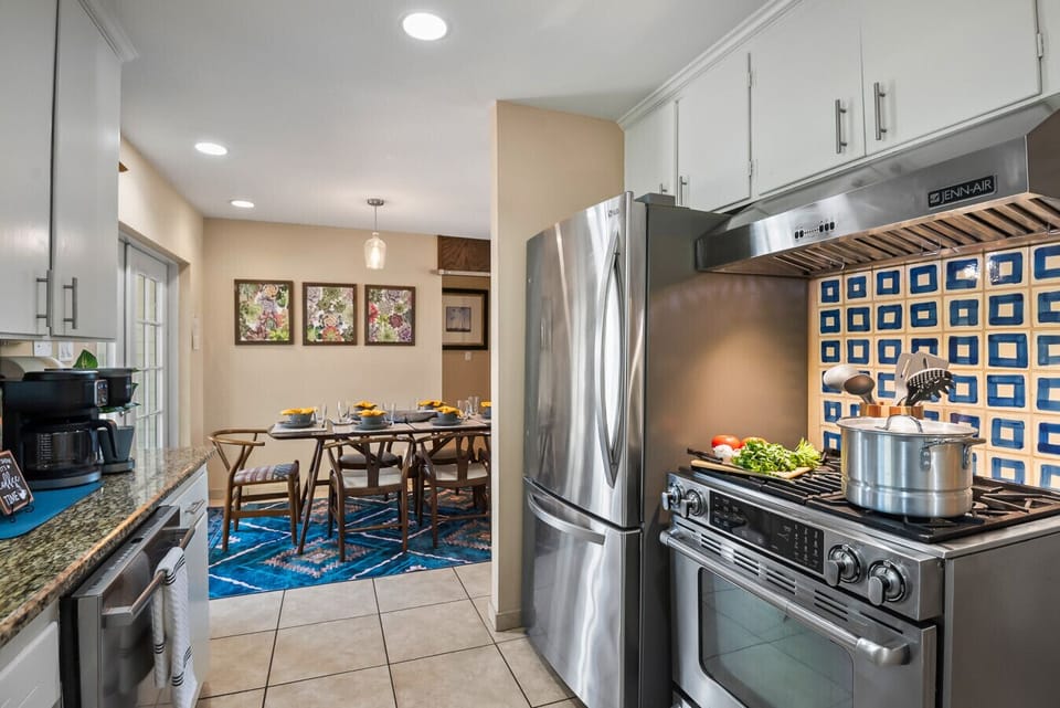 Kitchen: Bright culinary haven with modern appliances, vibrant backsplash, and inviting dining setup!