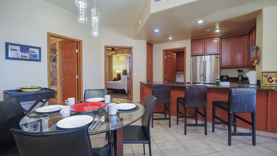 The dining table sits near bar stools and the kitchen counter.