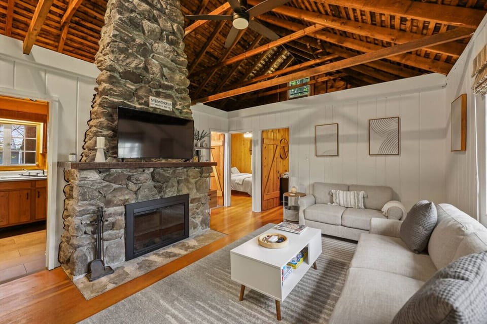 Cozy living room featuring a stunning floor-to-ceiling stone fireplace with mounted TV, perfect for relaxing after a day of adventures.