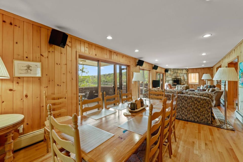 Open dining area with long wooden table and chairs, seamlessly connected to the living room and kitchen.