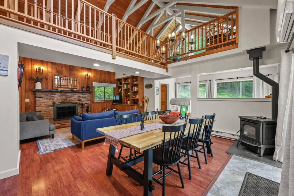 Rustic-modern dining area with high ceilings, comfortable seating, and plenty of natural light.