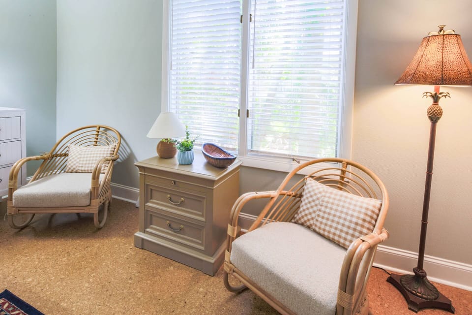 The guest suite features a seating area and floor lamp near the window.